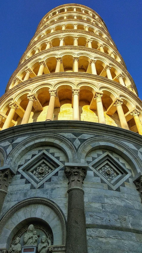 a very tall building with pillars against a blue sky