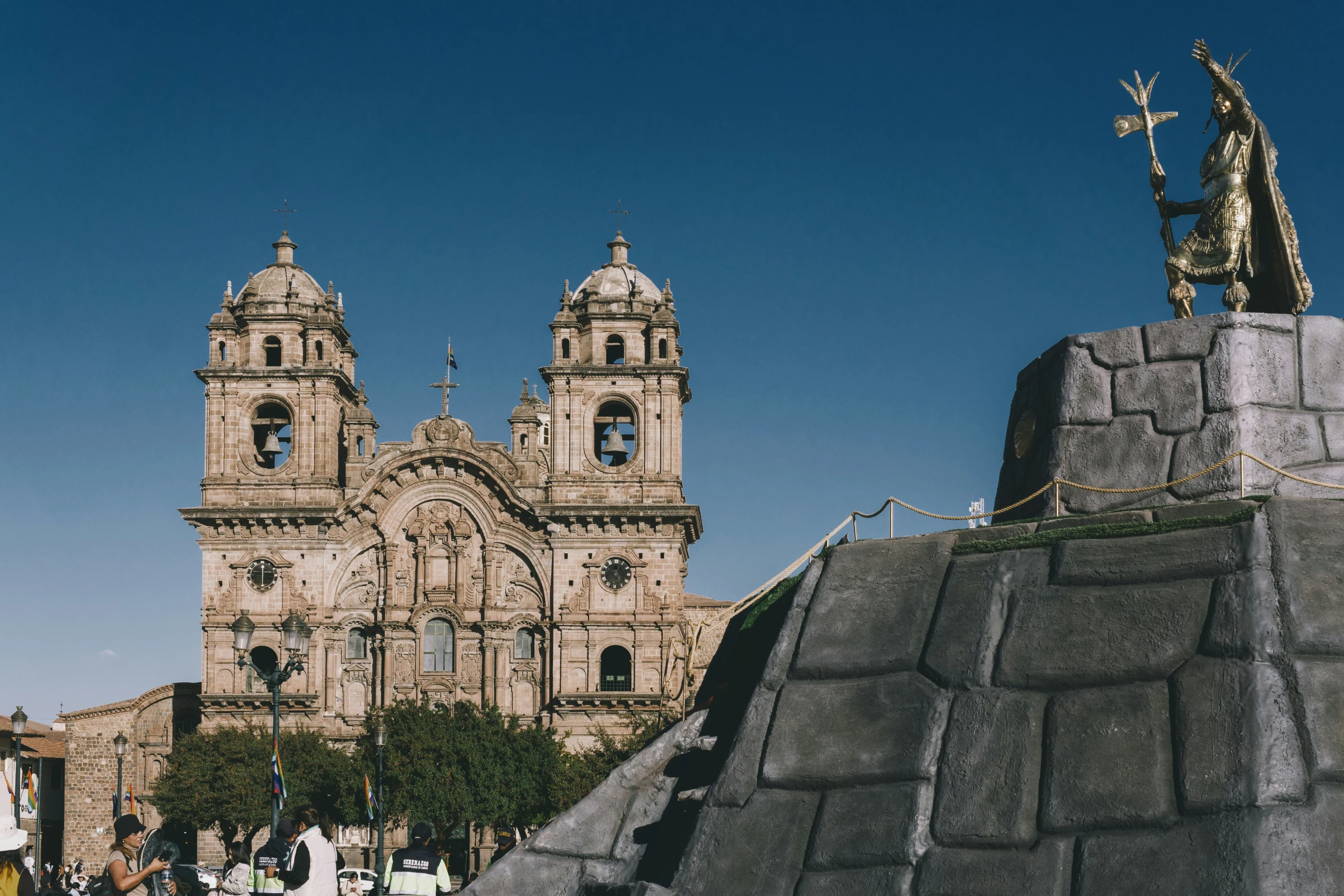 a group of people walk down the street towards some ancient buildings