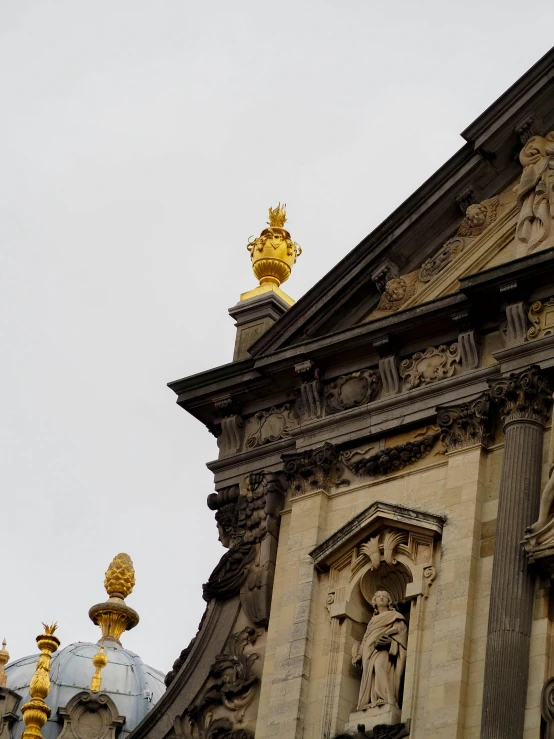 the top of an ornate building with a gold object atop