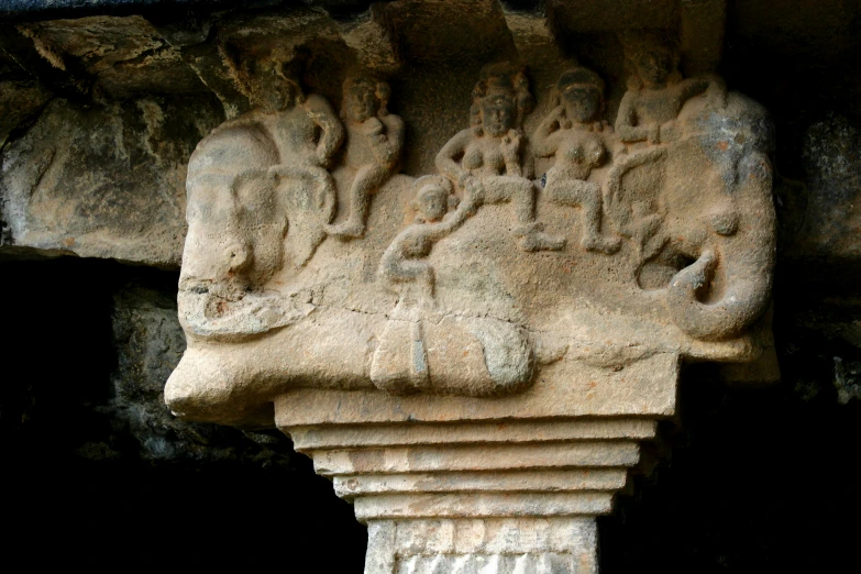 a large sculpture of animals and people sitting on some sort of pillar