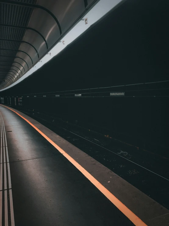 a empty train station in the dark with a car parked