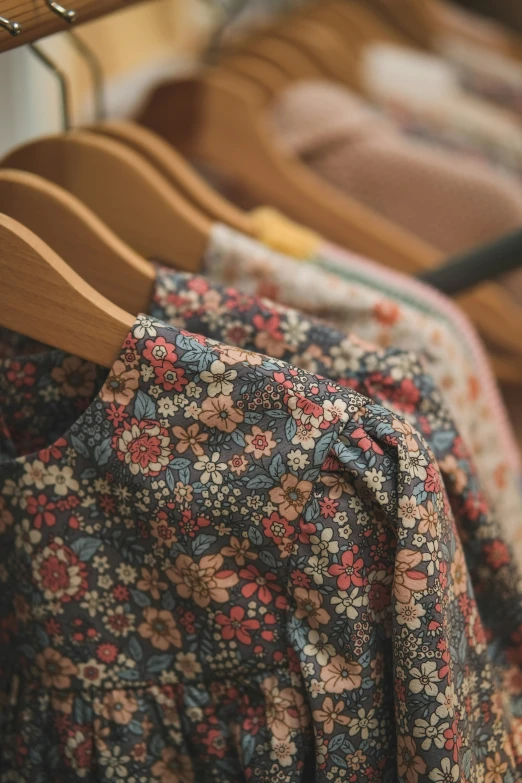 clothes hang up on wooden racks in a shop