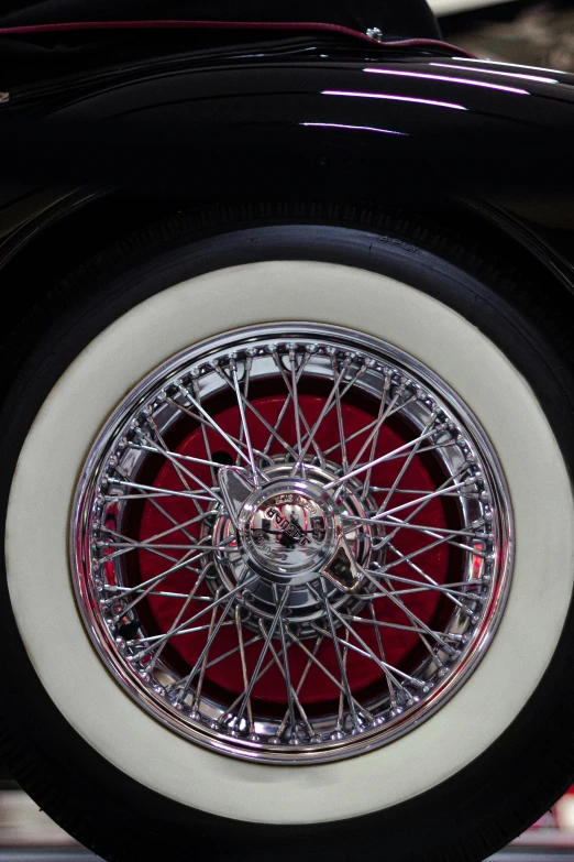 the wheel of a parked car is showing spokes