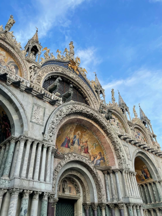 a large cathedral has a wall with paintings on it