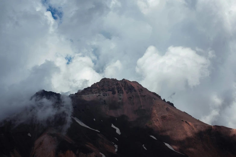 the mountain is surrounded by clouds and a blue sky