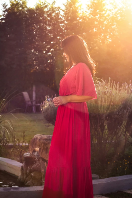 a woman in a red dress in front of flowers