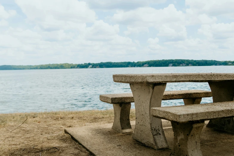 a concrete bench sits overlooking the water