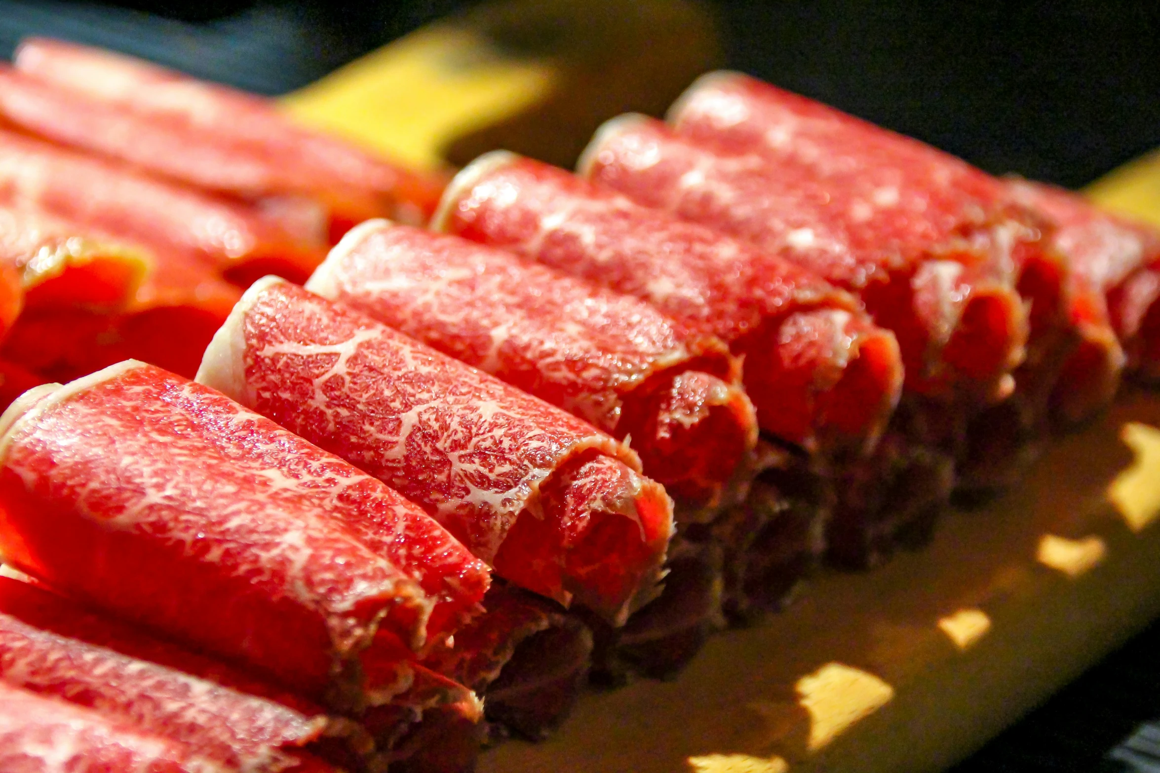 several small slices of meat sitting on a yellow surface