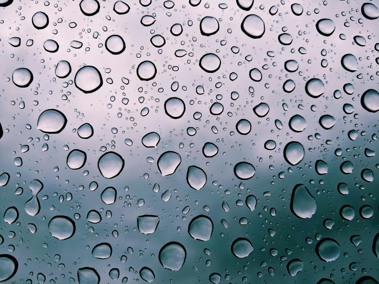 rain drops are on the window as it rains