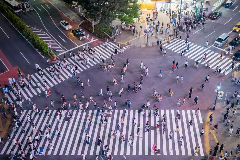 many pedestrians are crossing the street in a city at night