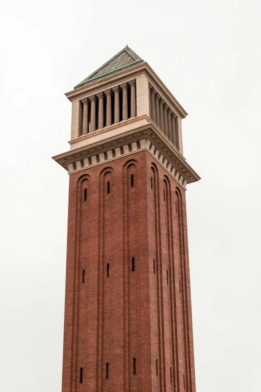 an old red brick clock tower against a cloudy sky