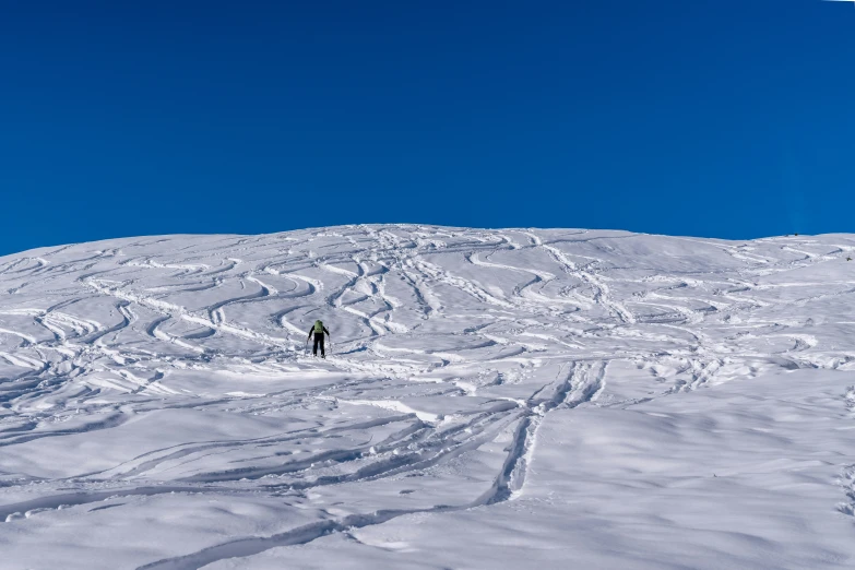 a person skiing down a snowy mountain on a clear day