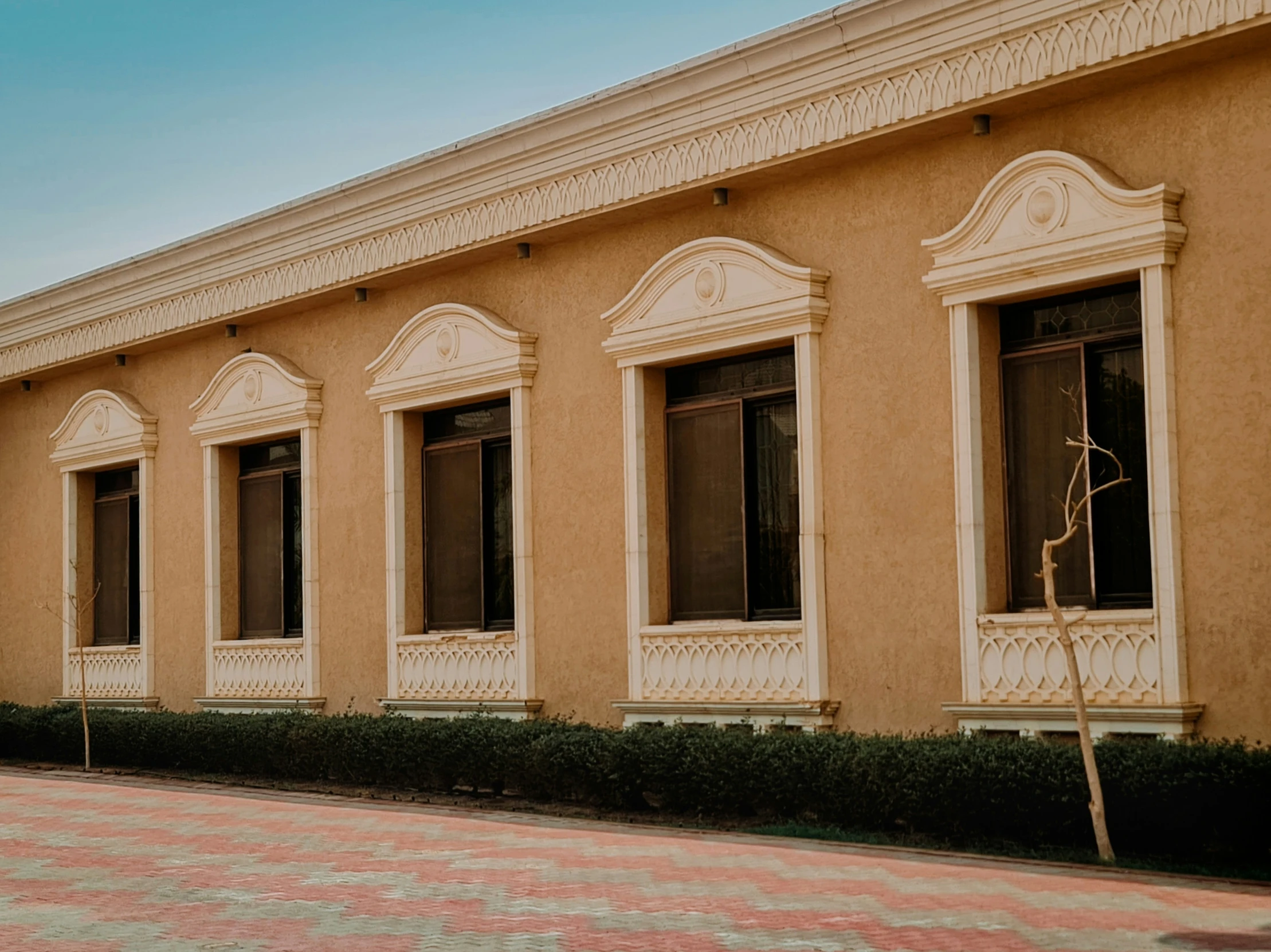 an old building with multiple arched windows and a few bushes