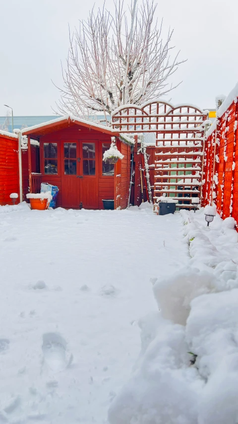 a red barn stands next to a snowy landscape