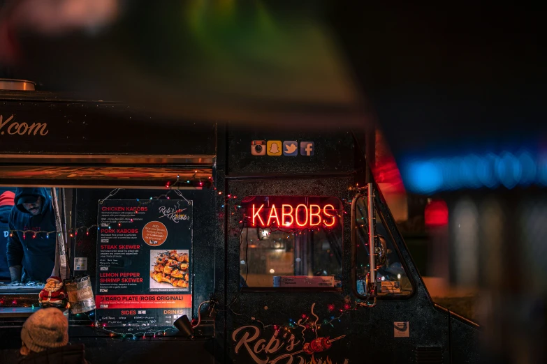 a man in the dark at night behind an ice cream cart