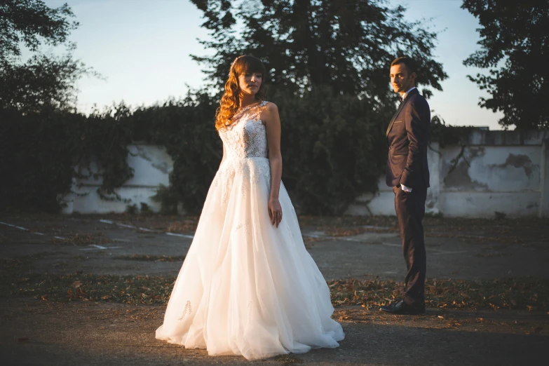 two people dressed up for their wedding, one of them is looking at the bride and the other is staring away