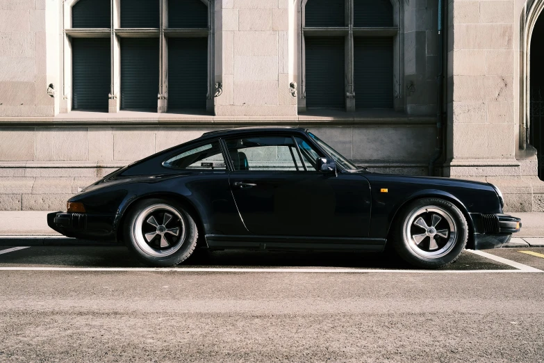 the rear view of a black car parked on the street