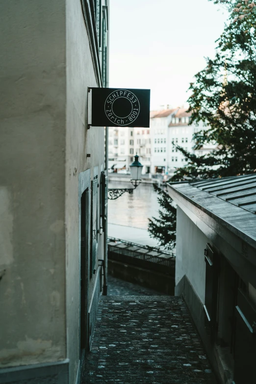 a sign hanging from the side of a building over looking water