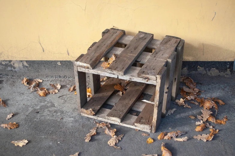 an arrangement of wooden crates sitting outside on the floor