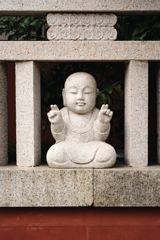 a statue of buddha with one hand extended out on a ledge