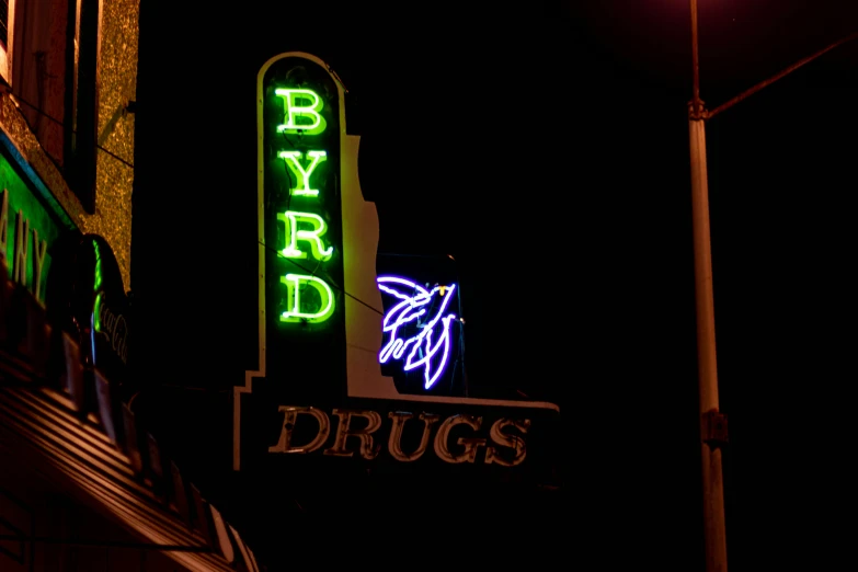 a dark image of some signs on the side of a building