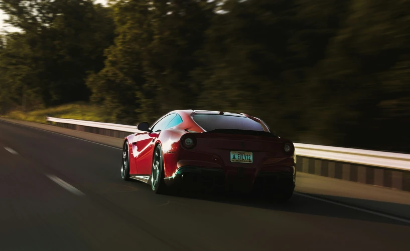 the front of a red car drives on the highway