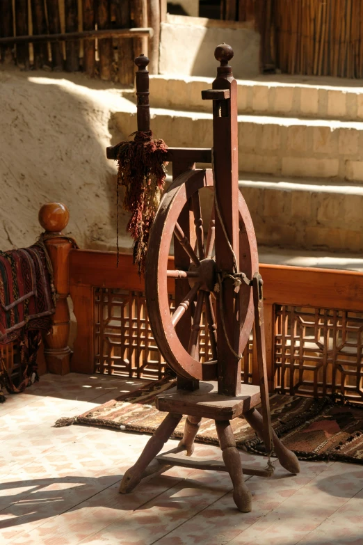 a spinning wheel next to a fence in a courtyard