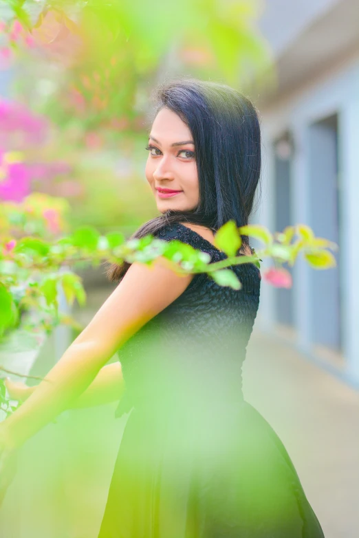 young woman in black dress with a green plant