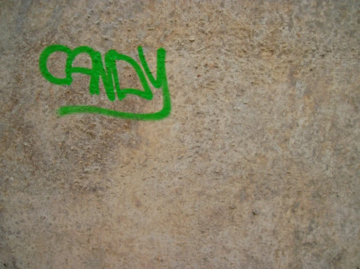 a graffiti - painted street sign on the side of a wall with writing