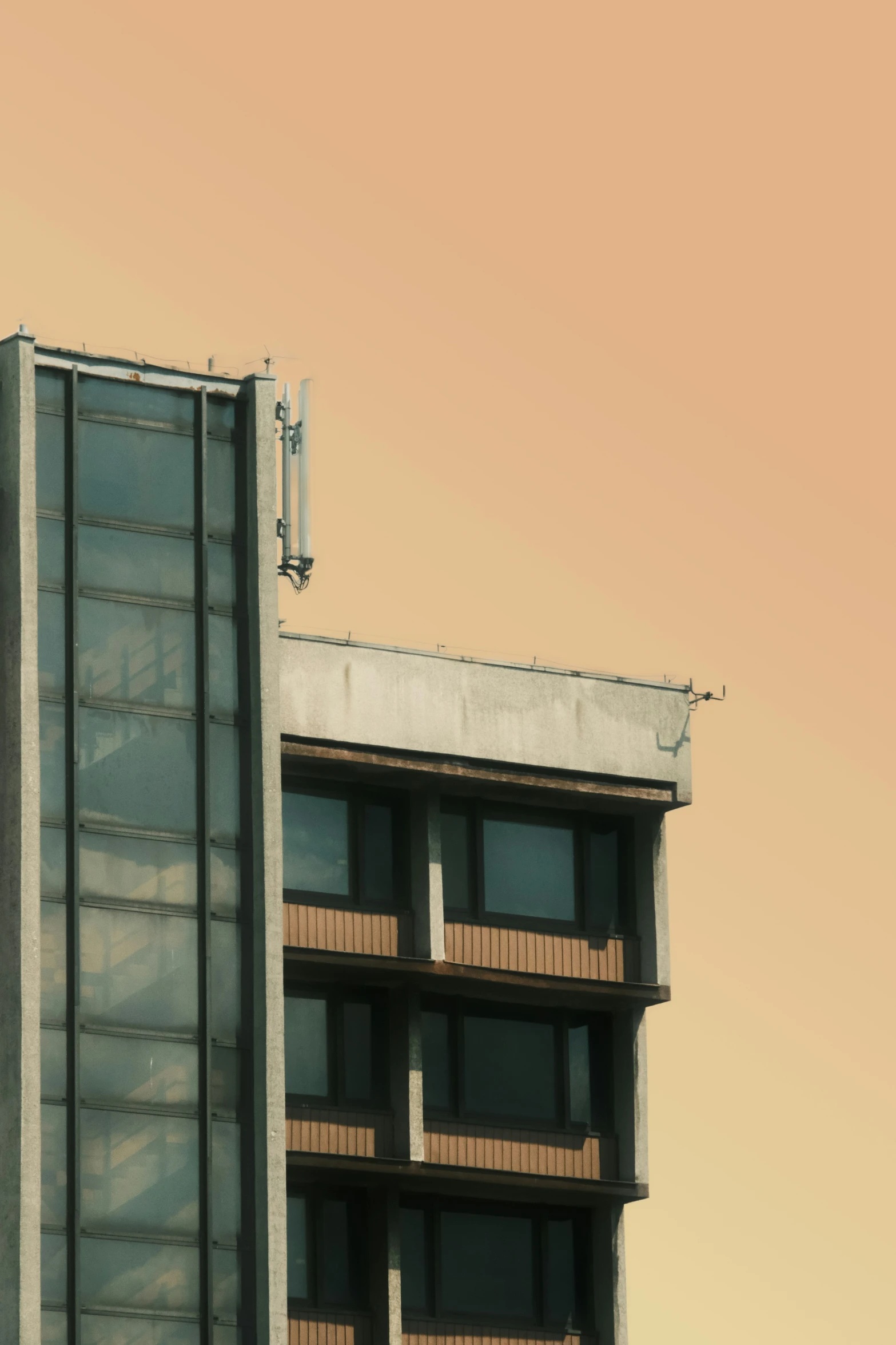 an apartment building is near to a tan sky