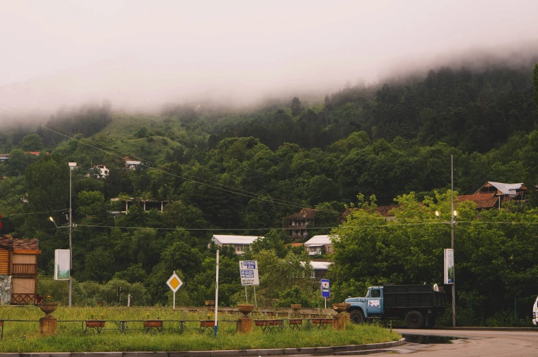 some mountains are in the background with cars parked