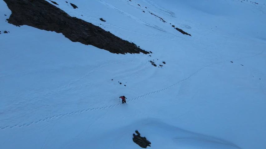 a man riding skis down a snow covered slope