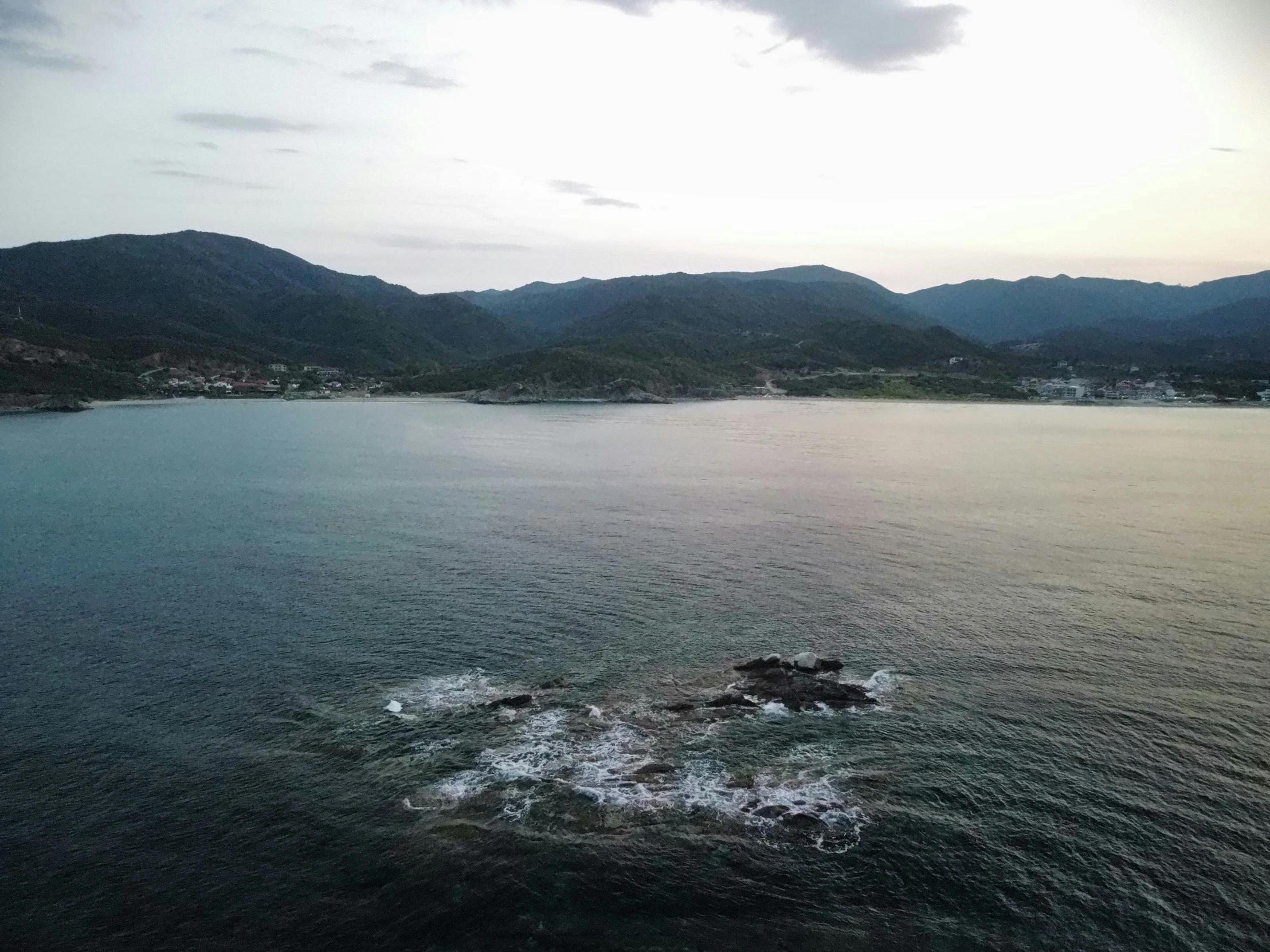 a body of water with some mountains in the background