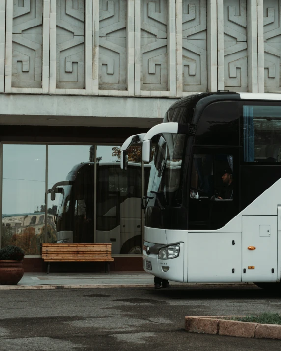 a white bus parked in front of a building