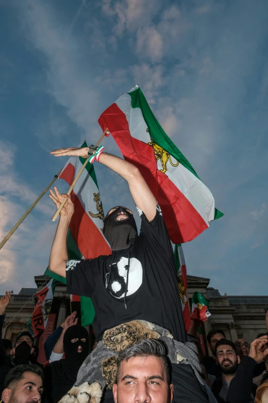 people are waving various national flags in front of a building