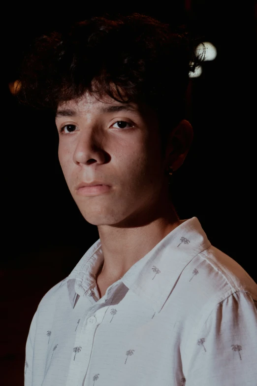 a young man with dark hair and white shirt