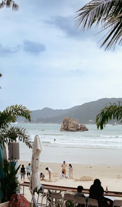 a beach filled with people and chairs under umbrellas