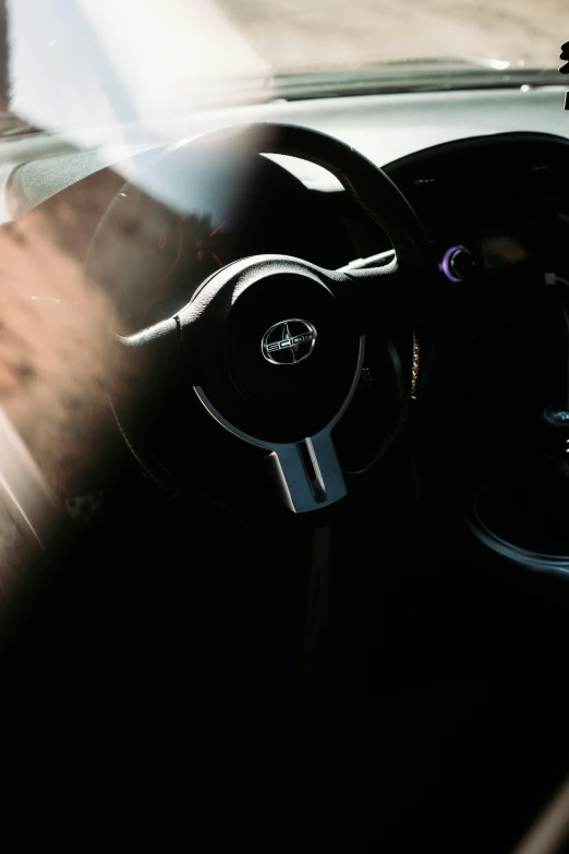 a steering wheel inside of a car near another vehicle