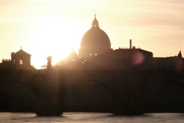 the sun sets behind two church silhouettes