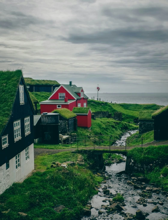 an old house with a green roof by the water