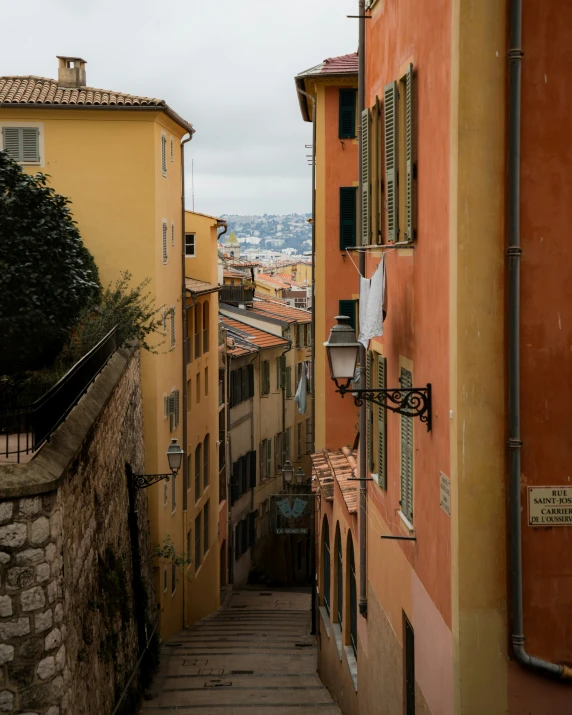 the narrow street is lined with small yellow buildings