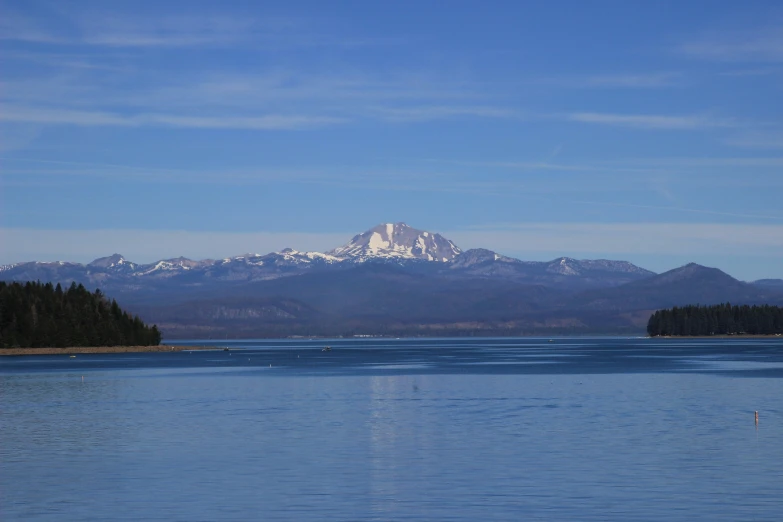 there is a boat out on the water with mountains in the background