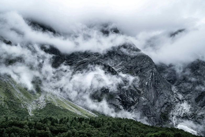 clouds rolling over the mountains and green grass