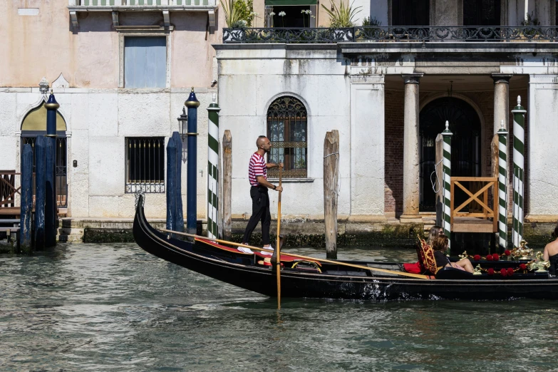 a man riding on the back of a boat in a canal