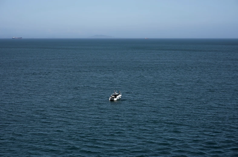 a lone boat floating in the middle of an ocean