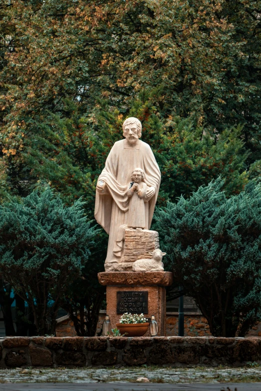 a statue of a person holding his hands together