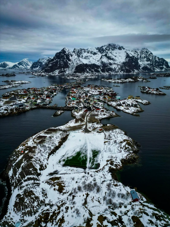 an island is in the middle of the sea and has a lot of snow on it