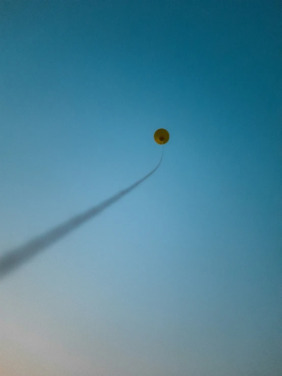 a yellow balloon flying in the blue sky