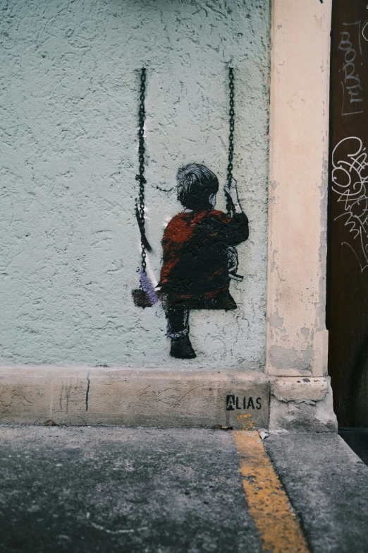 an older child holding a swing toy and sitting on it's back