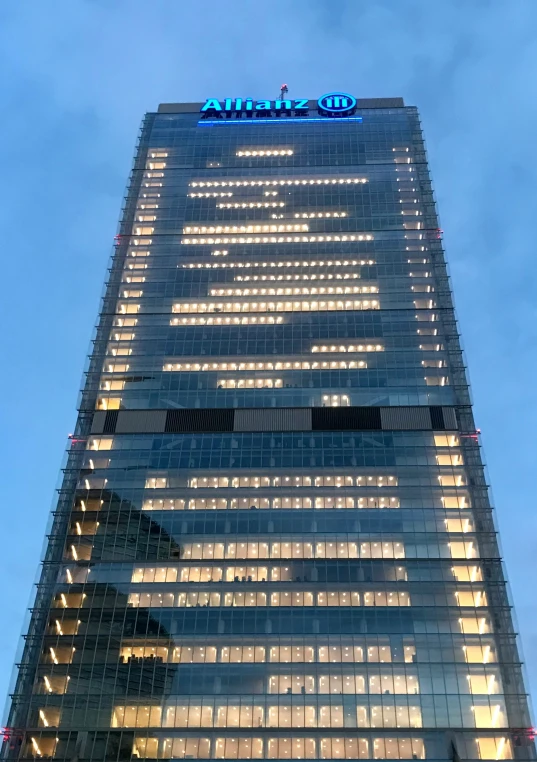 an office building lit up at night with lights on the side